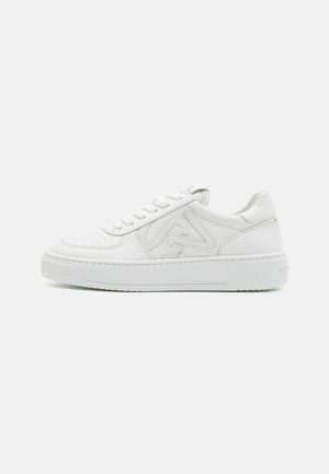 Weiße Low-Top-Sneaker mit perforiertem Seitenlogo, Schnürung an der Vorderseite, gepolstertem Kragen und dicker Gummisohle auf einem einfarbigen Hintergrund.