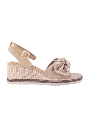 Sandalia de cuña beige con plataforma tejida, hebilla en la correa del tobillo y gran lazo decorativo en la correa frontal.