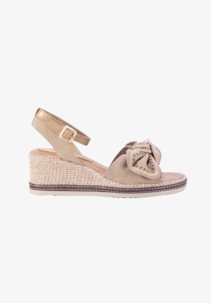 Sandalia de cuña beige con plataforma tejida, hebilla en la correa del tobillo y gran lazo decorativo en la correa frontal.