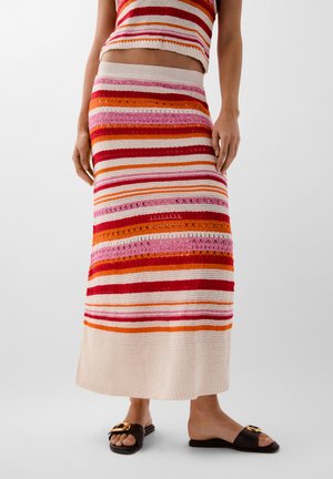 Gonna maxi in maglia con righe orizzontali in rosso, rosa, arancione e crema. Presenta una vita elastica e una texture simile all'uncinetto.