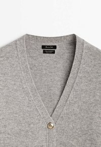 Cardigan gris clair en laine et cachemire mélangés, col en V, avec un seul bouton décoratif argenté sur le col avant.