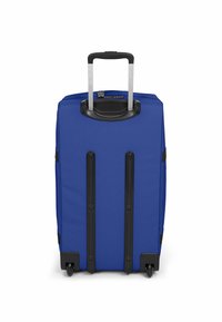 Modrý kufr vyrobený z texturované tkaniny, vybavený teleskopickou černou rukojetí, zesíleným dnem s kolečky a zipovým uzávěrem.
