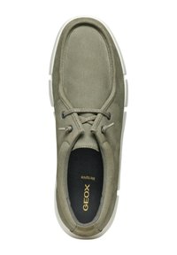 Zapatilla de ante verde con forma redondeada, cordones grises y suela de goma blanca. Presenta un diseño perforado y un interior de tela.