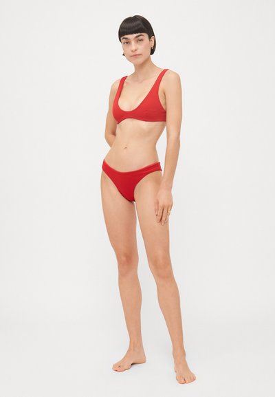 Ensemble bikini rouge comprenant un haut à encolure dégagée avec des bretelles larges et un bas taille basse, fabriqué à partir d'un tissu extensible lisse, design minimaliste.