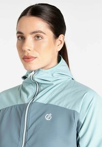 Leichte Reißverschlussjacke in Türkis und Grau. Mit hohem Kragen, kontrastierendem Einsatz und kleinem Logo auf der Brust. Glatte Textur.