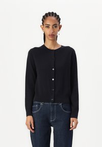 Black cardigan made of soft fabric, round neckline, and long sleeves. Features a button closure down the front with contrasting buttons.