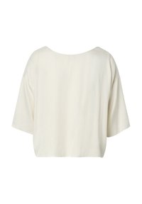 Haut ample crème à manches courtes avec un large col rond et une coupe carrée légèrement raccourcie, vu de dos.