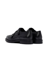 Black leather shoes with a glossy finish, featuring two metal buckles and a rugged sole. Sturdy design with a rounded toe and low heel.