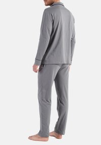 Grijze katoenen pyjama set met een lange mouw top met kraag en bijpassende broek, gladde textuur en een relaxte pasvorm.