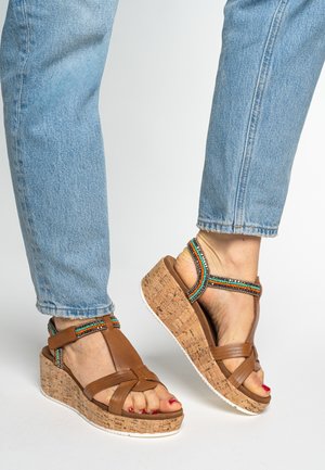 Brown wedge sandals with cork platform, featuring colorful bead accents on the straps and a smooth leather finish.