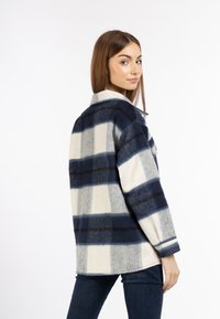 Karierte Flanelleuchte in Marineblau, Weiß und Grau. Merkmale einen Kragen, lange Ärmel und einen lockeren Schnitt. Ausgeprägte horizontale Streifen.
