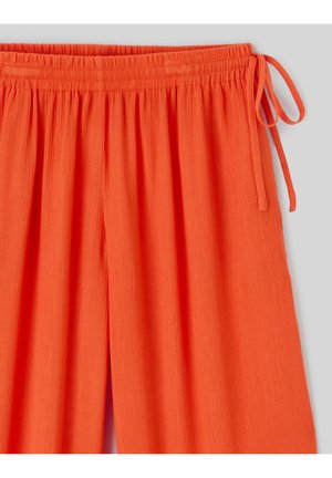 Pantalon large orange vif avec taille élastique et détail noué sur le côté, en tissu léger et texturé.