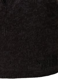 Black knit beanie made from soft fabric, featuring a smooth texture and a logo embossed on the side. Simple and snug fit design.