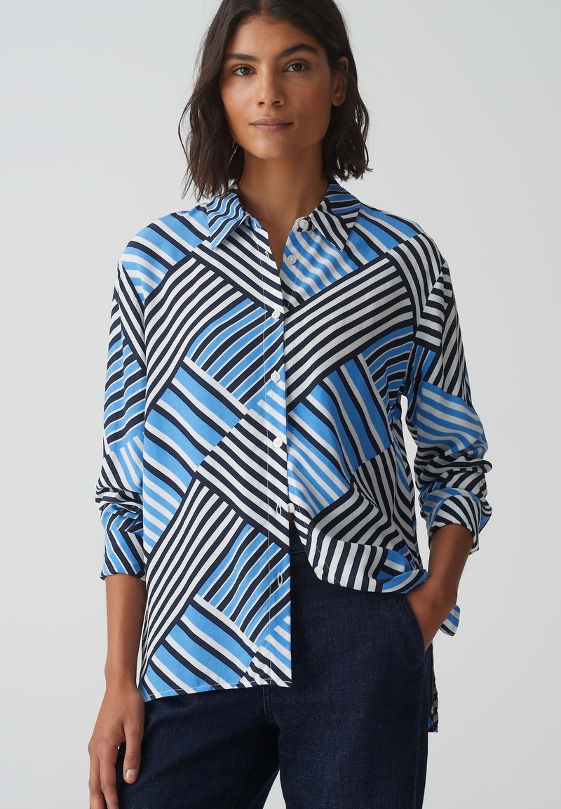 Camicia con bottoni, caratterizzata da un design geometrico con strisce diagonali blu e nere, realizzata in tessuto leggero, con colletto alla francese e maniche lunghe.