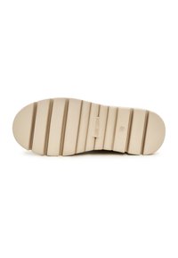 Suela de zapato de goma beige con estrías horizontales, puntera redondeada y detalle de logo en relieve. Textura robusta con múltiples surcos de tracción.