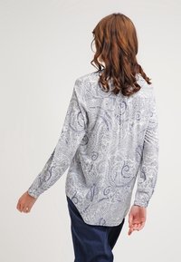 Camicia a maniche lunghe grigia chiaro con motivo paisley blu, dotata di colletto button-down e orlo curvo, realizzata in un tessuto morbido.