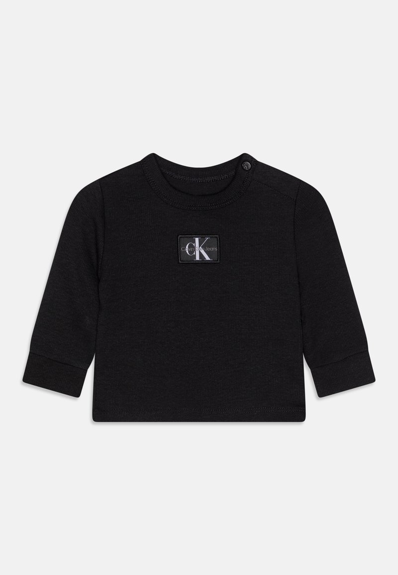 Camiseta negra de manga larga para niños pequeños, confeccionada en tela suave con cuello redondo, que presenta una etiqueta con un logo blanco en el frente y cierres de presión en el hombro.