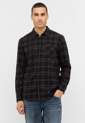 Schwarzes Flanellhemd mit grün-braunem Karomuster, langen Ärmeln, Button-Down-Kragen und Brusttasche. Trägt man mit blauen Jeans.