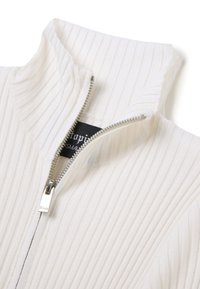 Maglione zip-up bianco a coste con collo alto e dettaglio della cerniera in argento. Etichetta interna visibile, che indica la misura e il marchio.