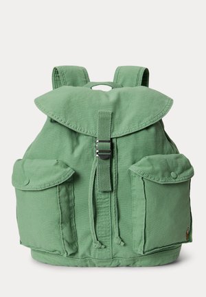 Zaino in tela verde con chiusura a patta, cinturino centrale con fibbia, coulisse, due tasche anteriori con bottone e spallacci imbottiti.