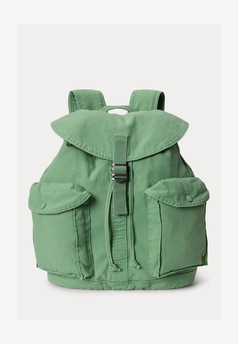 Πράσινο καμβά σακίδιο με κλείσιμο με καπάκι, κεντρικό λουράκι με αγκράφα, κορδόνια σφίξιμο, δύο μπροστινές τσέπες με κουμπιά και επενδεδυμένους ιμάντες ώμου.