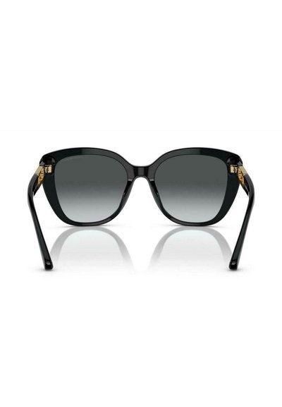 Occhiali da sole neri oversize con lenti scure sfumate e dettagli dorati sulle tempie, mostrati frontalmente su uno sfondo bianco.