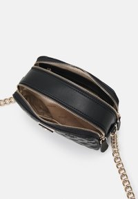 Borsa a tracolla in pelle nera con scomparti con zip, tracolla a catena e dettagli testurizzati. Interno beige con logo del marchio.