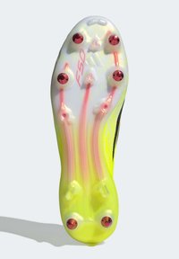 Σόλα με καρφιά και διαφανή λευκή βάση, φωτεινές κίτρινες πινελιές, κόκκινα καρφιά και ροζ γραμμές πρόσφυσης. Διαθέτει λογότυπο "F50".