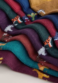 Chaussettes tricotées colorées dans diverses nuances, ornées de motifs d'animaux. Tissu texturé avec des couleurs distinctes : vert, rouge, violet, sarcelle et jaune.