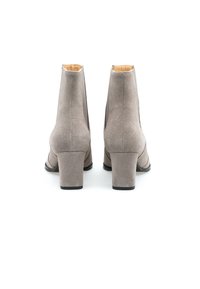 Bottines en daim gris avec un design effilé, des talons empilés, une texture lisse et une silhouette minimaliste. Aucun élément métallique ou motif visible.