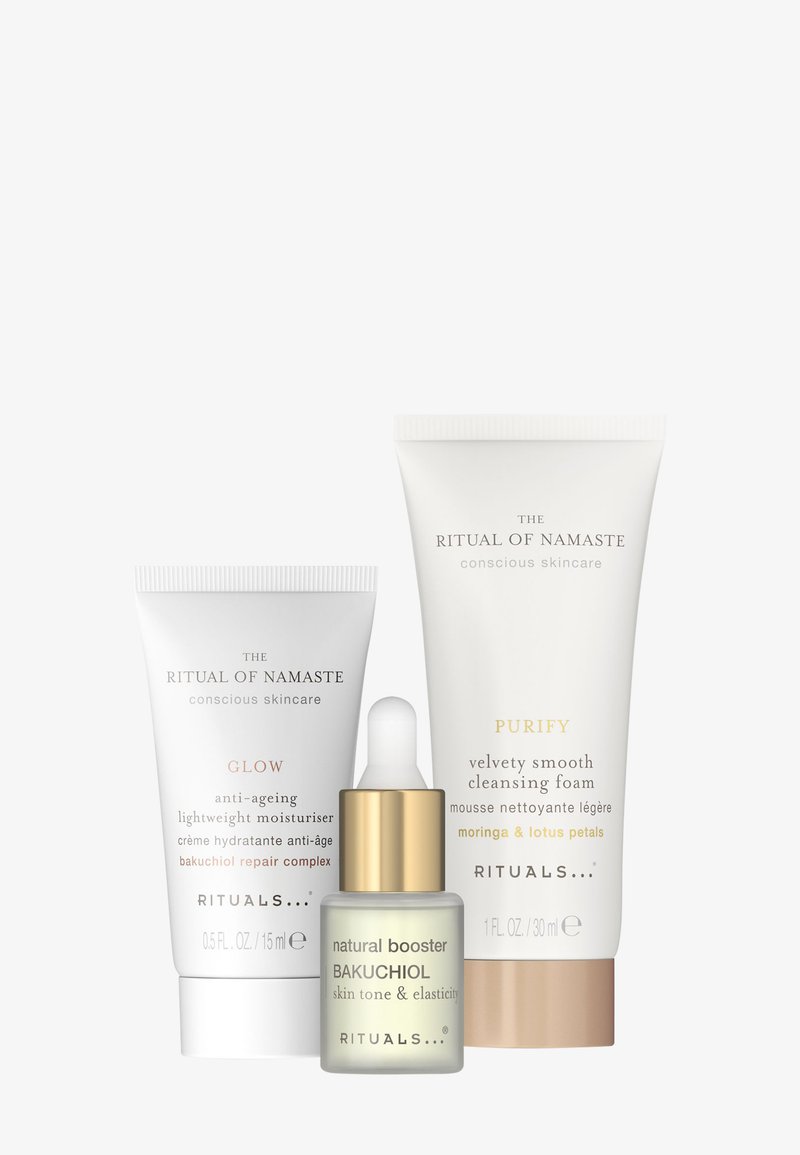 Tres productos para el cuidado de la piel: un tubo blanco etiquetado "Glow" para crema hidratante anti-envejecimiento, un tubo blanco para espuma limpiadora "Purify" y un frasco con gotero de "boost natural Bakuchiol".