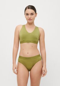 Bralette verde-oliva e calcinhas combinando, feitas de tecido suave, apresentando uma textura lisa e uma faixa com logótipo, com um design simples.