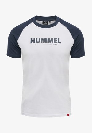 Weißes T-Shirt mit marineblauen Raglanärmeln, das das "HUMMEL"-Logo in großen, dunklen Buchstaben über der Brust und ein rotes Etikett unten links zeigt.