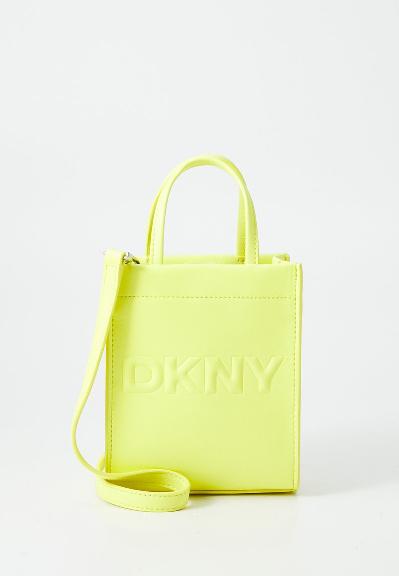 Neon rumena torba DKNY z embosiranim logotipom, strukturirano obliko, dvema ročama in nastavljivim čez ramo trakom. Gladka tekstura.