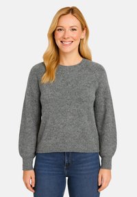 Maglione grigio lavorato a maglia con maniche lunghe e gonfie e un collo rotondo, realizzato in un materiale morbido e testurizzato. Abbinato a jeans blu.