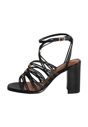 Black strappy heeled sandal with intertwined straps, gold accents, square toe, and a chunky heel. Smooth leather texture and minimal design.