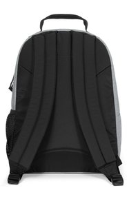 Reppureppu, jossa on harmaa kangasrunko, mustat pehmustetut hihnat, kestävä kahva ja verkkopussi sivulla lisätallennusta varten.