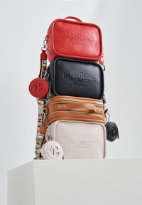 Set di tre borse a tracolla impilate in pelle rossa, nera, beige e bianca con dettagli in logo impresso e tracolla staccabile.