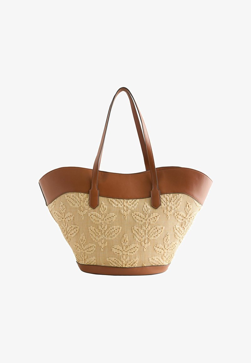 Sac cabas beige tissé avec garniture en cuir marron, motif de feuilles et deux longues bandoulières.