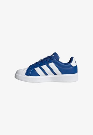 Zapatilla baja con parte superior azul, puntera blanca, tres rayas blancas en el lateral, suela blanca y cordones azules.