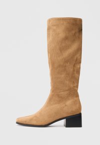 Bottines en daim tan jusqu'au genou avec talon bloc et bout pointu, présentées de côté sur un fond clair.