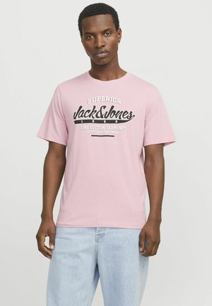 Svijetloružičasta pamučna majica s crnim grafičkim tekstom koji kaže "Superior Jack & Jones Fine Cotton Garments" i opuštenim krojem.