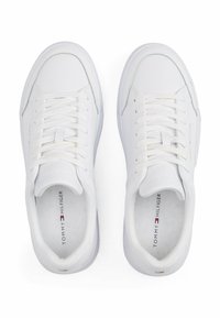 Sneaker bianche in pelle con texture liscia, punta tonda, chiusura con lacci e design minimalista con dettaglio del logo sulla linguetta.
