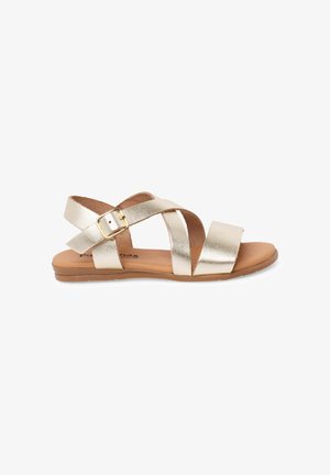 Płaska sandałka z metalicznymi złotymi paskami krzyżowymi, regulowaną złotą klamrą oraz beżową wyściełaną podeszwą.