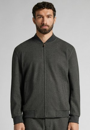 Graue Bomberjacke mit glatter Textur, Reißverschluss vorne, geripptem Kragen und Bündchen, seitlichen Taschen und slim fit Design.