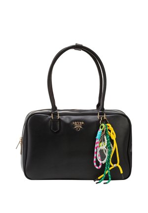 Schwarze Lederhandtasche mit goldfarbenen Beschlägen und bunten geflochtenen Schlüsselanhängern, darunter ein kleiner Tennisracket-Anhänger, der an einem Griff hängt.