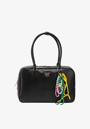 Schwarze Lederhandtasche mit goldfarbenen Beschlägen und bunten geflochtenen Schlüsselanhängern, darunter ein kleiner Tennisracket-Anhänger, der an einem Griff hängt.