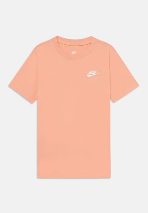 Kortærmet ferskenfarvet Nike T-shirt med hvidt logo på venstre bryst og rund hals, vist på en ensfarvet lys baggrund.