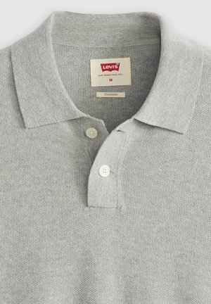 Maglione polo grigio a maglia con tessuto testurizzato, due bottoni bianchi e colletto classico. L'etichetta riporta "Levi's" con taglia media.