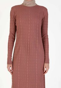 Abito a maniche lunghe in rosa polveroso con texture a coste e dettagli. Presenta un collo rotondo e polsini aderenti. Realizzato in morbido tessuto elasticizzato.
